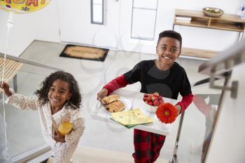 Children Bringing Parents Breakfast In Bed On Tray To Celebrate Birthday Mothers Day Fathers Day