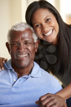 Portrait Of Smiling Senior Father Being Hugged By Adult Daughter At Home