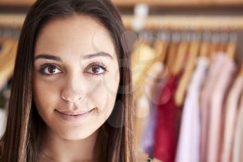 Portrait Of Female Customer Or Owner Standing By Racks Of Clothes In Independent Fashion Store