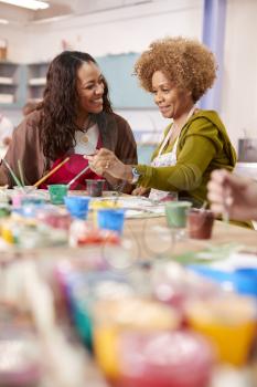 Two Mature Women Attending Art Class In Community Centre Together