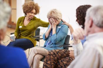 Unhappy Woman Attending Self Help Therapy Group Meeting In Community Center