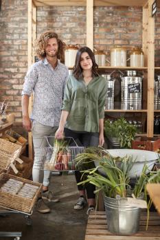 Portrait Of Couple Buying Fresh Fruit And Vegetables In Sustainable Plastic Free Grocery Store