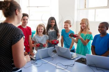 Group Of Students In After School Computer Coding Class Learning To Program Robot Vehicle