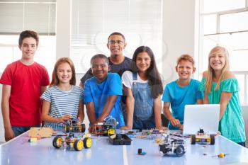 Portrait Of Students With Teacher Building Robot Vehicle In After School Computer Coding Class