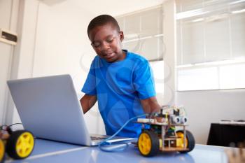 Male Student Building And Programing Robot Vehicle In After School Computer Coding Class