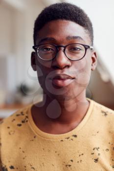 Portrait Of Young Man Wearing Glasses In Loft Apartment