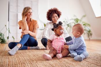 Two Mothers Meeting For Play Date With Babies At Home In Loft Apartment