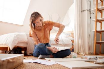 Woman In New Home Putting Together Self Assembly Furniture