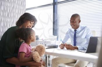 Mother And Daughter In Consultation With Doctor In Office