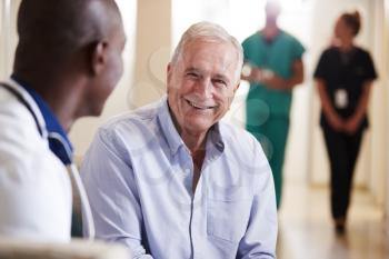 Doctor Welcoming To Senior Male Patient Being Admitted To Hospital