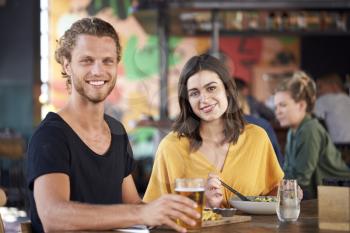 Portrait Of Couple On Date Meeting For Drinks And Food In Restaurant