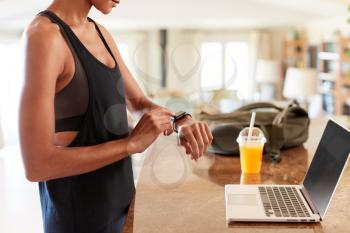 Mid section of African American woman checking fitness app on smartwatch after the gym