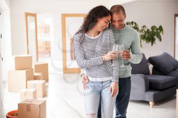 Couple Celebrating Moving Into New Home Making A Toast With Champagne