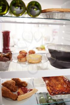 View Inside Refrigerator Of Unhealthy Takeaway Food And Beer On Shelves