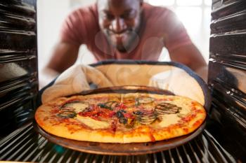 View Looking Out From Inside Oven As Man Cooks Fresh Pizza