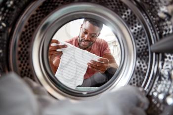 View Looking Out From Inside Washing Machine As Man Takes Out Baby Clothes