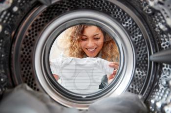 View Looking Out From Inside Washing Machine As Woman Takes Out Baby Clothes
