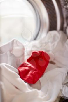 View Looking Out From Inside Washing Machine With Red Sock Mixed With White Laundry