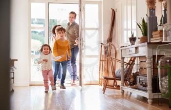 Family Returning Home After Trip Out With Excited Children Running Ahead