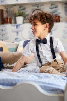 Boy Wearing Bowtie And Suspenders Getting Ready For Fathers Wedding