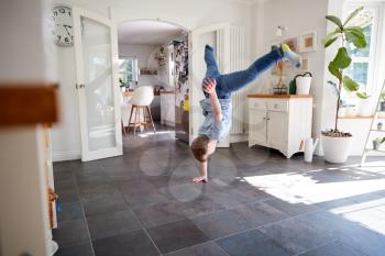 Young Downs Syndrome Man Having Fun Breakdancing At Home