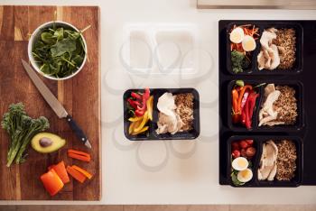 Overhead Shot Of Ingredients And Containers For Batch Of Healthy Meals At Home On Kitchen Counter