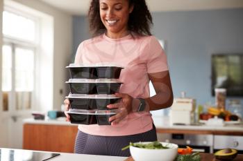 Woman Preparing Batch Of Healthy Meals At Home In Kitchen