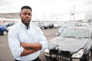 Portrait Of Motorist Standing Next To Car Damaged In Motor Accident