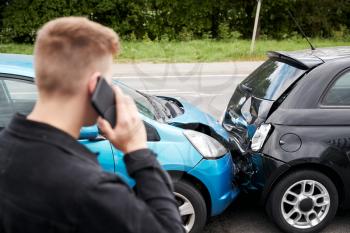 Young Male Motorist Involved In Car Accident Calling Insurance Company Or Recovery Service