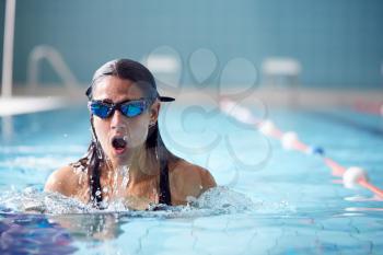 Female Swimmer Wearing Goggles Training In Swimming Pool