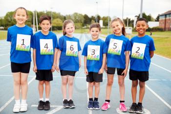 Portrait Of Children On Athletics Track Wearing Competitor Numbers On Sports Day