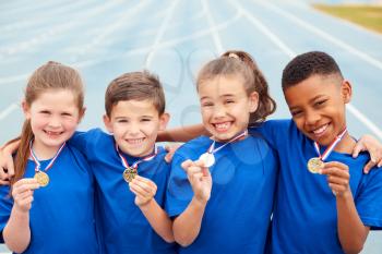 Portrait Of Children Showing Off Winners Medals On Sports Day