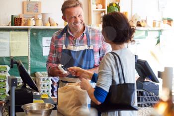 Customer At Checkout Of Organic Farm Shop Making Contactless Payment