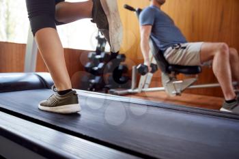 Detail Of Couple In Home Gym Exercising With Weights And Using Running Machine