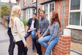 Group Of College Students Outside Rented Shared House Talking And Laughing