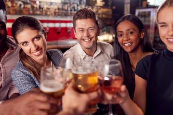 Point Of View Shot Of Male And Female Friends Making A Toast As They Meet For Drinks In Bar