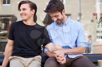 Loving Male Gay Couple Sitting Outside Coffee Shop Holding Hands
