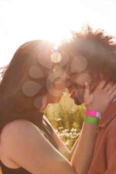 Head And Shoulders Close Up Of Young Romantic Couple Hugging In Countryside Field With Setting Sun
