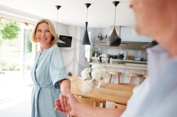 Loving Senior Couple At Home In Kitchen Together Holding Hands