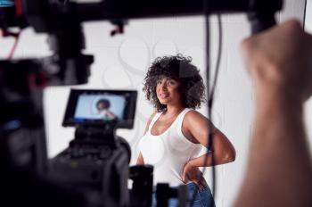 Female Model Posing For Video Camera On Film Set