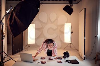 Female Photographer Editing Images From Photo Shoot In Studio