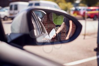 Man Charging Electric Vehicle Reflected In Car Side Mirror