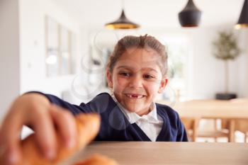 Mischievous Girl Wearing School Uniform Taking Croissant From Kitchen Counter