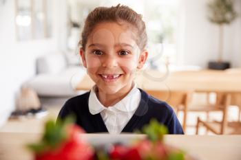 Mischievous Girl Wearing School Uniform Taking Strawberry From Kitchen Counter