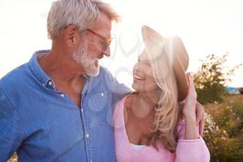 Loving Mature Couple In Countryside Hugging Against Flaring Sun