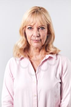 Studio Shot Of Mature Woman With Serious Expression Against White Background At Camera