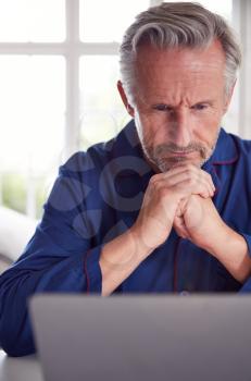 Serious Mature Man Looking Up Information Online Using Laptop