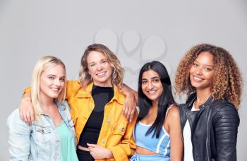 Group Studio Portrait Of Multi-Cultural Female Friends Smiling Into Camera Together