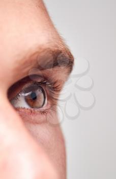 Extreme Close Up Of Eye Of Man Against White Studio Background