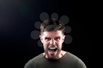 Head And Shoulders Studio Shot Of Angry Man Shouting At Camera